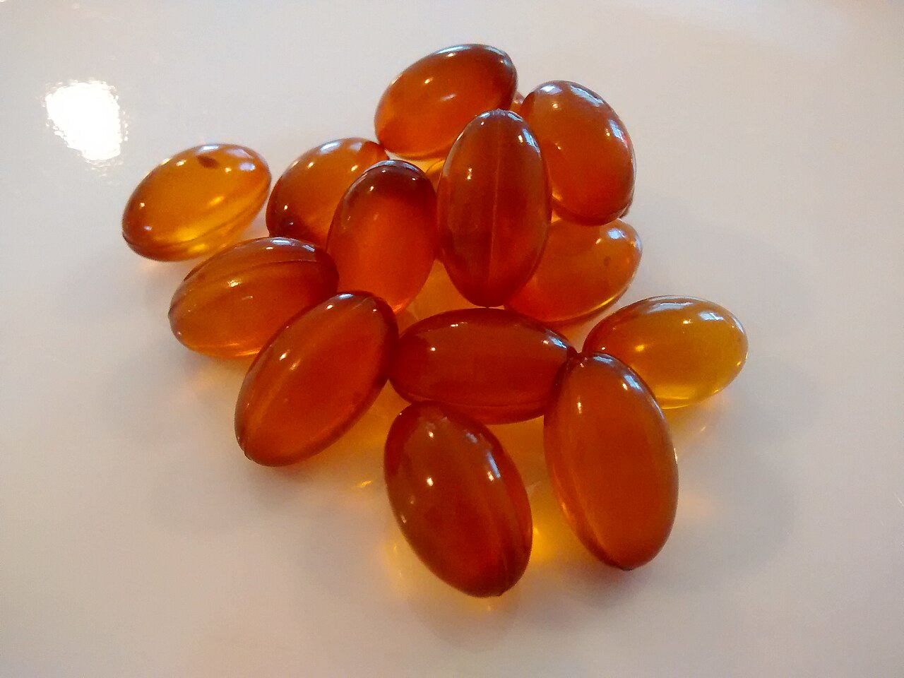 Amber softgel supplement capsules on a white surface